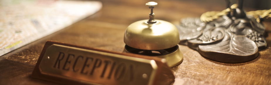 a reception bell and a reception sign on a wood table