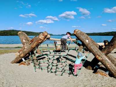 Children playing on a wooden structure by the beach